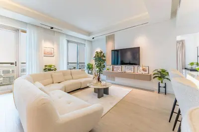 a living room with a white couch and a tv at Golf Course And Canal Views, Mins to Dubai Marina And Dubai Mall, Golf Towers T1 - The Greens by Deluxe Holiday Homes in Dubai