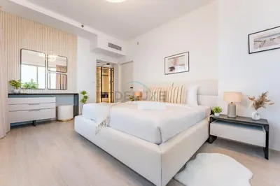 a white bedroom with a large bed and a mirror at Golf Course And Canal Views, Mins to Dubai Marina And Dubai Mall, Golf Towers T1 - The Greens by Deluxe Holiday Homes in Dubai