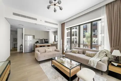 a living room with a couch and a table at Stylish 2BR at Creek Grove Near Downtown in Dubai