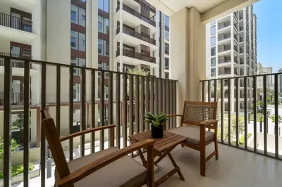a balcony with two chairs and a table at Stylish 2BR at Creek Grove Near Downtown in Dubai