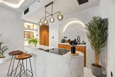 a kitchen with a counter with stools and a sink at Art Studio - Cozy Loft, Fireplace, City Vistas in Dubai