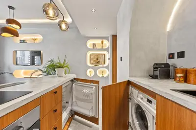 a kitchen with a washer and dryer in it at Art Studio - Cozy Loft, Fireplace, City Vistas in Dubai