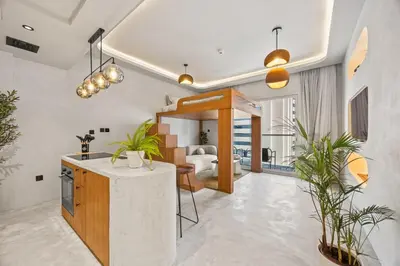 a kitchen with potted plants and a living room at Art Studio - Cozy Loft, Fireplace, City Vistas in Dubai
