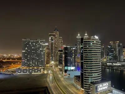 a night view of a city with buildings at Art Studio - Cozy Loft, Fireplace, City Vistas in Dubai