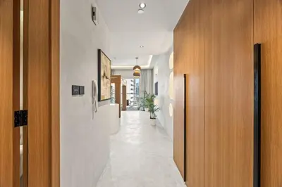 a hallway with white walls and wooden doors at Art Studio - Cozy Loft, Fireplace, City Vistas in Dubai