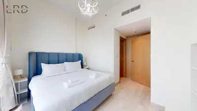 a bed with a blue headboard in a room at Cozy and Modern 1BR for 2 in Dubai