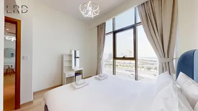 a bedroom with a white bed and a large window at Cozy and Modern 1BR for 2 in Dubai