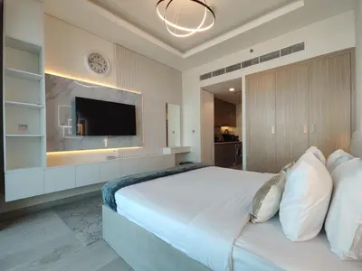 a bedroom with a large white bed with a flat screen tv at Farhad Azizi Residence Al Jaddaf in Dubai