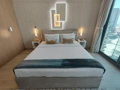 a large bed in a room with a large window at Farhad Azizi Residence Al Jaddaf in Dubai