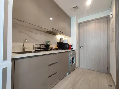 a kitchen with a sink and a washing machine at Farhad Azizi Residence Al Jaddaf in Dubai