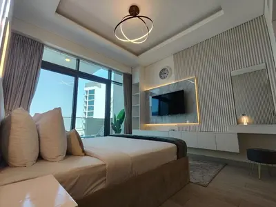 a bedroom with a large bed with a large window at Farhad Azizi Residence Al Jaddaf in Dubai