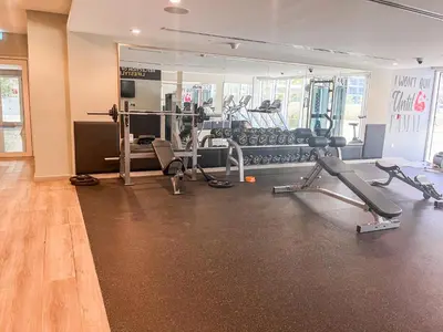 a gym with several treadmills and machines in a room at Stylish 1BR - Burj Khalifa View in Dubai