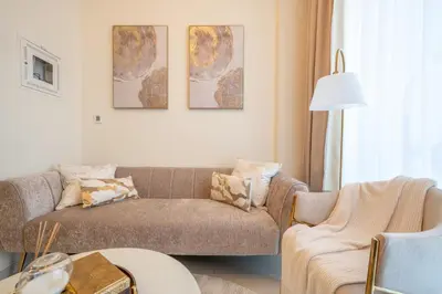 a living room with a couch and two chairs at Stylish 1BR - Burj Khalifa View in Dubai