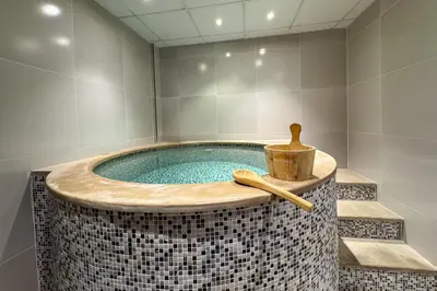 a bathroom with a jacuzzi tub with a wooden bowl at Designer Loft Studio with top Amenities in JVC in Dubai