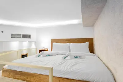 a bedroom with a bed with white sheets and pillows at Designer Loft Studio with top Amenities in JVC in Dubai