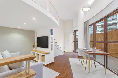 a living room with a dining table and a tv at Designer Loft Studio with top Amenities in JVC in Dubai
