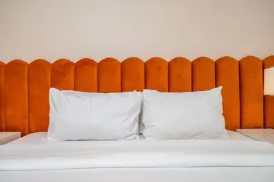 a bed with two white pillows in front of a wooden headboard at Ultra-Luxury Midtown 2 Bed Full Burj Khalifa Views in Dubai
