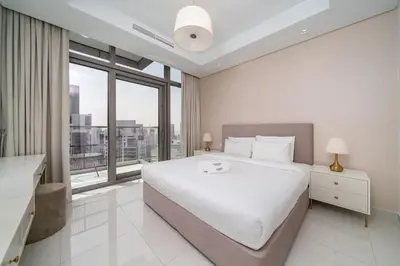 a white bedroom with a large bed and a large window at Ultra-Luxury Midtown 2 Bed Full Burj Khalifa Views in Dubai
