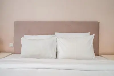 a bed with white pillows and a headboard at Ultra-Luxury Midtown 2 Bed Full Burj Khalifa Views in Dubai
