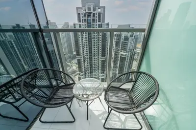 a balcony with three chairs and a table on a skyscraper at Ultra-Luxury Midtown 2 Bed Full Burj Khalifa Views in Dubai