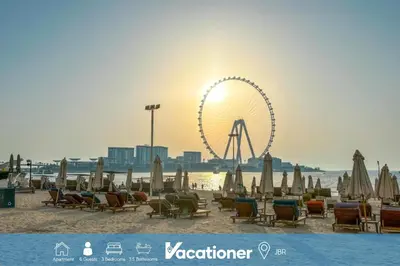a beach with a ferris wheel in the background at Vacationer I Royale 3 Bedroom I Steps to JBR Beach I Jumeirah I Free Gym, Pool, Parking & Wi-Fi in Dubai