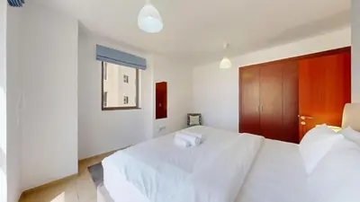 a bedroom with a white bed with two pillows on it at Vacationer I Royale 3 Bedroom I Steps to JBR Beach I Jumeirah I Free Gym, Pool, Parking & Wi-Fi in Dubai