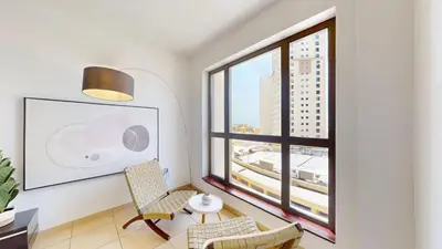 a living room with a table and chairs and a large window at Vacationer I Royale 3 Bedroom I Steps to JBR Beach I Jumeirah I Free Gym, Pool, Parking & Wi-Fi in Dubai