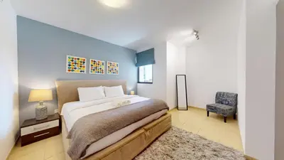 a bedroom with a large bed and a chair at Vacationer I Royale 3 Bedroom I Steps to JBR Beach I Jumeirah I Free Gym, Pool, Parking & Wi-Fi in Dubai