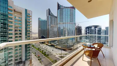 a balcony with two chairs and a view of a city at Vacationer I Premium 1 Bedroom I Canal View I Business Bay I Free Gym, Pool, Parking & Wi-Fi in Dubai