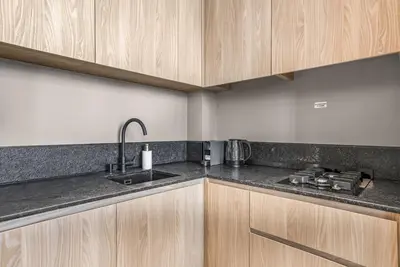a kitchen with wooden cabinets and a sink at Stylish Studio in The Autograph in Dubai