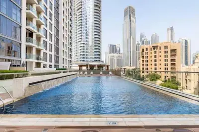 a large swimming pool in a city with tall buildings at Vogue Downtown Bellevue Towers near Burj Khalifa and Dubai Mall, One Bedroom Apartment with City View, Full Access to all Amenities in Dubai