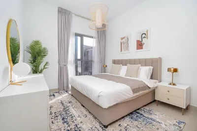 a white bedroom with a large bed and a mirror at Vogue Downtown Bellevue Towers near Burj Khalifa and Dubai Mall, One Bedroom Apartment with City View, Full Access to all Amenities in Dubai