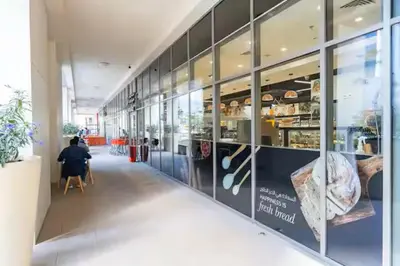 a person sitting in a chair in front of a store at Vogue Downtown Bellevue Towers near Burj Khalifa and Dubai Mall, One Bedroom Apartment with City View, Full Access to all Amenities in Dubai