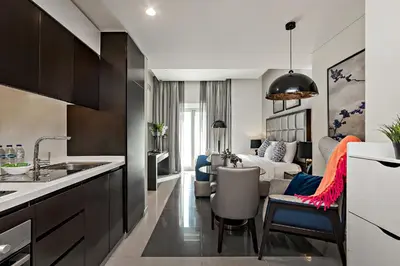 a kitchen and a living room with a couch at Studio with a Large Terrace at DAMAC Majestine in Dubai
