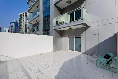 a building with a chair and a balcony on it at Studio with a Large Terrace at DAMAC Majestine in Dubai