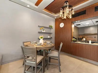 a dining room with a table and chairs and a clock at Luxury 1 Bedroom Marina Views Walk to Metro and Beach in Dubai