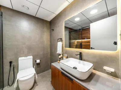 a bathroom with a sink and a toilet and a mirror at Luxury 1 Bedroom Marina Views Walk to Metro and Beach in Dubai