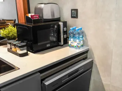 a counter with a microwave and two bottles of water at Luxury 1 Bedroom Marina Views Walk to Metro and Beach in Dubai