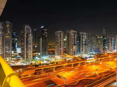 a city at night with traffic on a freeway at Luxury 1 Bedroom Marina Views Walk to Metro and Beach in Dubai