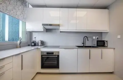 a kitchen with white cabinets and a sink at Luxury 2 BHK in Dubai Marina By dPie DEC 1907 in Dubai