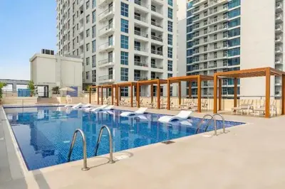a large swimming pool in a building with tall buildings at Luxury 2 BHK in Dubai Marina By dPie DEC 1907 in Dubai