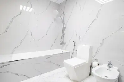 a white bathroom with a toilet and a sink at Luxury 2 BHK with Floating Bed in Dubai Marina DEC 1803 in Dubai