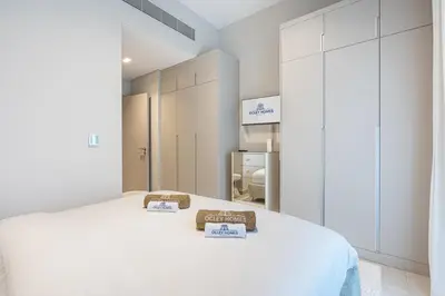 a white room with a bed with two signs on it at Lovely Duplex Townhouse minutes from Downtown in Dubai