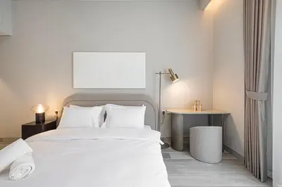 a bedroom with a white bed and a table at Luxury 1 BHK in Jumeirah Village Circle BydPie Concept 302 in Dubai
