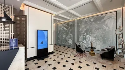 a room with two chairs and a wall with paintings at Luxury 1 BHK in Jumeirah Village Circle BydPie Concept 302 in Dubai