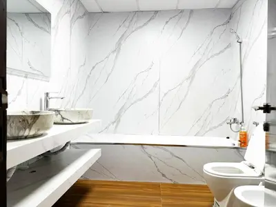 a bathroom with marble walls and a tub and a toilet at Luxury 3BHK in Dubai Marina DEC 1603 in Dubai