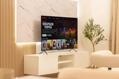 a tv sitting on a white stand in a living room at Luxury 3 BHK in Dubai Marina By dPie Dec 1007 in Dubai
