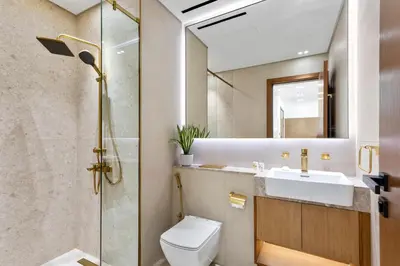 a bathroom with a toilet and a sink and a mirror at Charming 1Bedroom in Binghatti Gardenia in Dubai