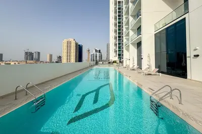 a swimming pool on the roof of a building at Charming 1Bedroom in Binghatti Gardenia in Dubai