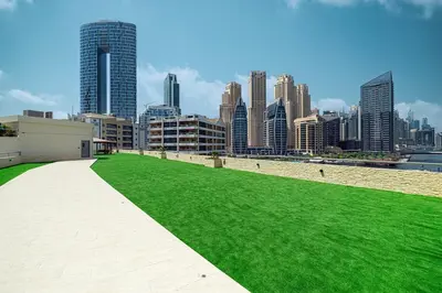 a field of green grass in front of a city at Luxury 3BHK in Dubai Marine By dPie DEC 903 in Dubai